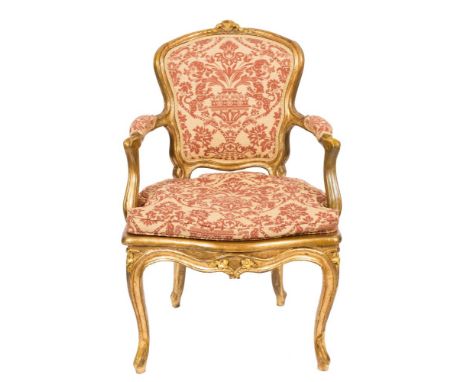 A 19th Century carved giltwood fauteuil:, in the Louis XV taste, with cane panel and upholstered cartouche-shaped back, padde