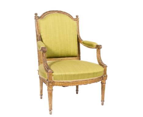 A 19th Century carved giltwood fauteuil in the Louis XVI taste:, the arched upholstered panel back in guilloche decorated fra