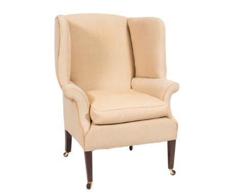 A mahogany wing frame armchair in the Georgian taste:, fully upholstered in oatmeal fabric and with loose cushion seat on squ