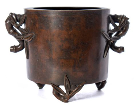 A Chinese inlaid bronze tripod incense burner: of cylindrical form with imitation bamboo handles and feet, inlaid with auspic