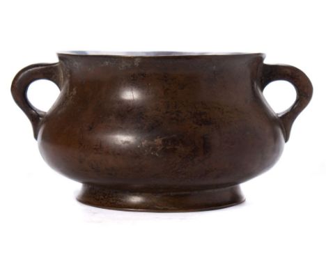 A Chinese bronze censer: of squat circular form, with loop handles to the side, on a circular foot, cast six-character Xuande