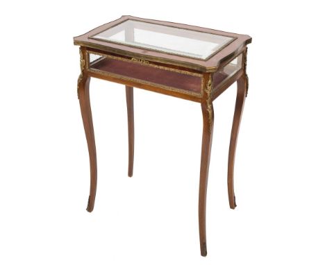 A mahogany and gilt metal and brass mounted bijouterie display table in the French taste:, with a serpentine bevelled glazed 