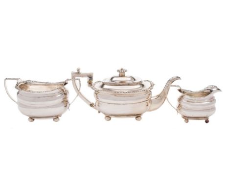 A late Georgian matched silver three-piece tea service, various makers and dates: of barge-shaped outline, with cushion girdl