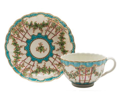 A First Period Worcester 'Hop Trellis' cup and saucer: of fluted form, painted with swags of red berried foliage suspended fr