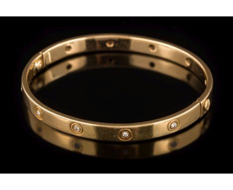 Cartier. A diamond mounted 'Love' bangle: signed 'Cartier', the hinged bangle stamped '750-18 711607' set with circular, bril
