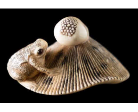 A Japanese carved ivory netsuke in the style of Garaku: carved as a toad seated on an upturned mushroom, with inset horn eyes