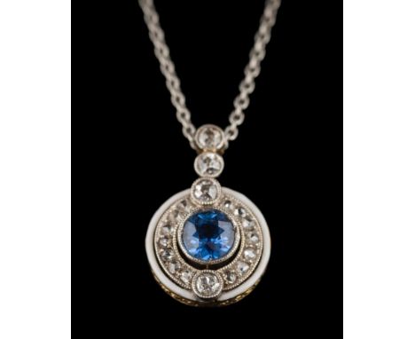 A sapphire and diamond circular pendant: the central sapphire approximately 5.2mm diameter x 3mm deep, within a surround of r