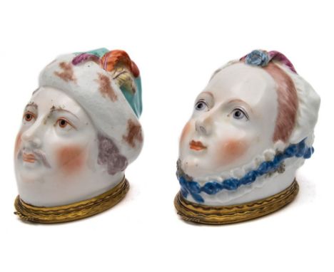 A matched pair of Chelsea bonbonnieres: modelled as a lady and a gentleman's head, she wearing a blue, pink and yellow trimme