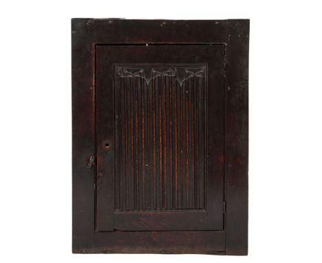 A 17th Century oak wall cupboard:, enclosed by a linen fold panel door, 65cm (2ft 1 1/2in) wide x 86.5cm (2ft 10in) high.