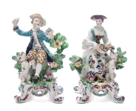 A pair of Bow figures of musicians: in the form of a lady playing a hurdy-gurdy, a dog at her feet, the companion figure of a