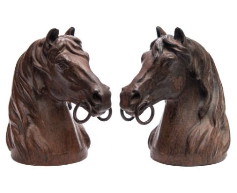 A pair of cast iron and bronze patinated busts: of horse's heads, each wearing a bit, unsigned 25.5cm. high.