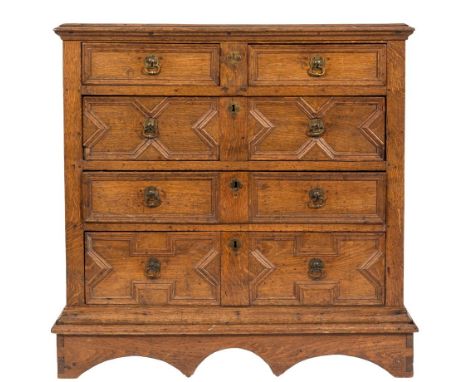 A 17th Century oak rectangular chest on a plinth stand:, the top with a moulded edge, containing two short and three long geo