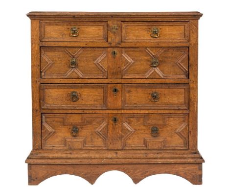 A 17th Century oak rectangular chest on a plinth stand:, the top with a moulded edge, containing two short and three long geo