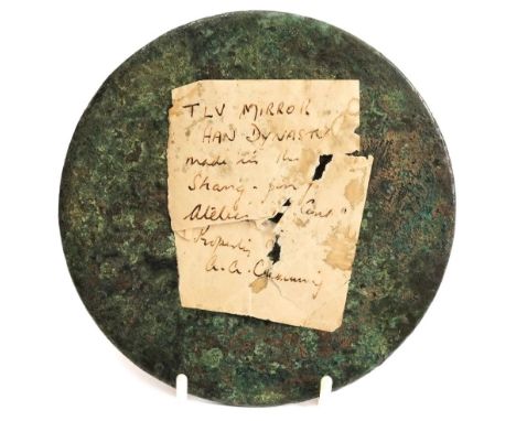 A Chinese bronze mirror, Han Dynasty: the reverse with central boss enclosed by concentric bosses and archaic decoration, 14c