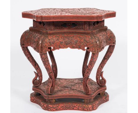 A Chinese carved wood and red lacquered veneer urn stand:, of shaped hexagonal outline, with all over decoration of peony blo