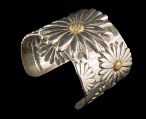 Tiffany & Co. A silver cuff bangle embossed with large daisy heads:, centred with textured yellow seeds, the cuff with applie