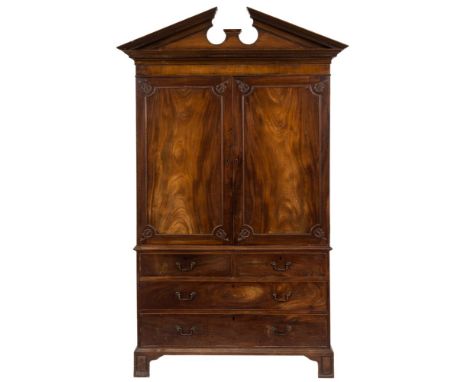 A George III mahogany linen press:, the upper part with an architectural moulded broken pediment with dentil ornament, fitted