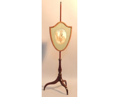 A Georgian mahogany pole screen, with shield shaped screen having an oval central embroidered panel of a figure in a landscap
