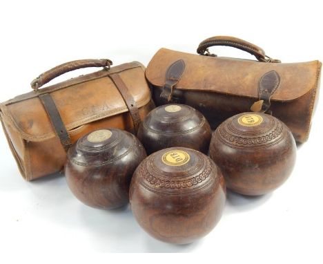 A set of four vintage lignum bowls, in two leather carry cases