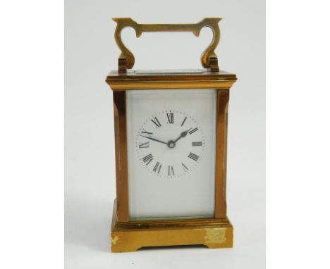 A brass cased carriage clock, with white enamel dial and Roman numerals, visible escapement and the rear plate stamped W J H,