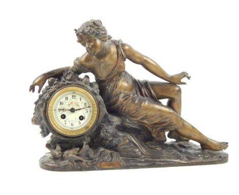 An early 20thC Continental reclining spelter figural mantel clock, the dial having floriate painted dial with Arabic numerals