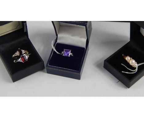 A 9ct white gold dress ring, set with a square brilliant cut synthetic amethyst and two white stones to the shoulders, a cult