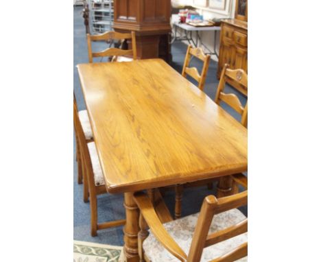 An elm dining room suite, comprising refectory style rectangular table with turned legs and flat centre stretchers and a set 