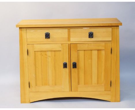 A light beech sideboard, fitted with two drawers and cupboards below enclosed by two panelled doors, 109cm wide