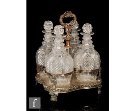 A 19th Century silver plated four bottle decanter stand the ring necked, diamond cut, clear glass decanters supported by a sh