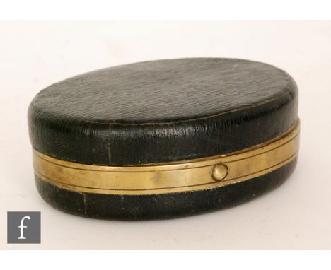 A 19th Century leather bound brass travelling ink or desk stand of oval form, with folding taper stick, ink well, knib wipe a