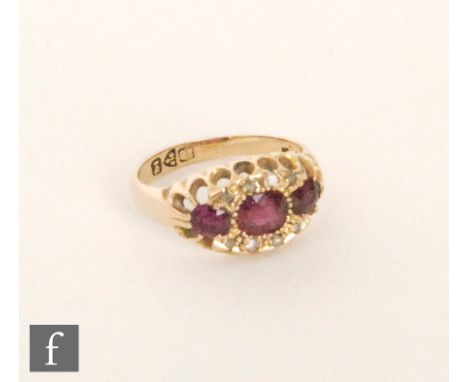 An early 20th Century 18ct hallmarked ruby and diamond ring, three oval rubies with diamond set borders, Chester 1911, ring s