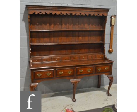 An 18th Century style oak dresser and rack, the moulded edge top over a shaped apron above a row of eight spice drawers and f