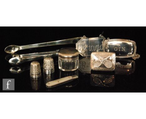 A small parcel lot of assorted hallmarked silver items to include two decanter labels, pill box, tongs, etc. (8). 