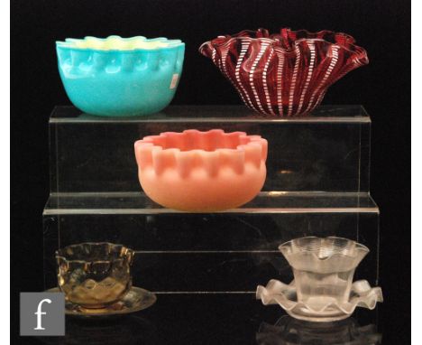 A late 19th Century miniature clear crystal finger bowl of circular form with a frill rim decorated with applied self colour 