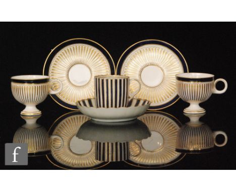 Two 19th Century Royal Worcester pedestal hot chocolate cup and saucer each with fluted gilding and royal blue border trims, 