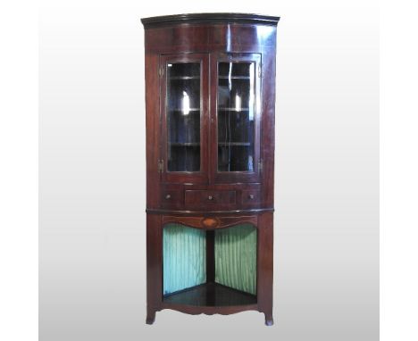 An Edwardian mahogany and inlaid bow front standing corner cabinet, with a glazed upper section, 90cm