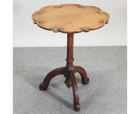 A Victorian Gothic carved light oak occasional table, with a shaped circular top, on a tripod base, 60cm