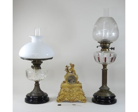 A Victorian brass oil lamp, with an etched glass shade, together with another, and a French gilt metal mantel clock (3)