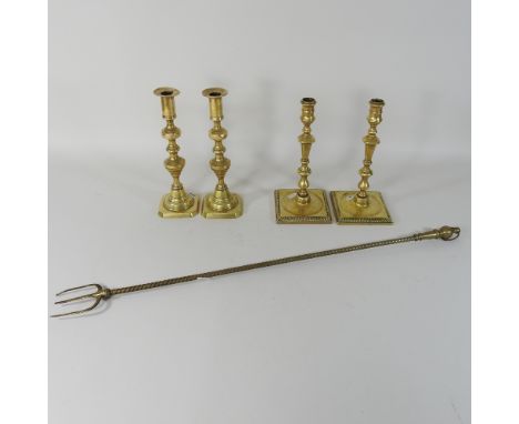 A pair of 18th century brass candlesticks, 27cm high, together with another pair and a brass toasting fork