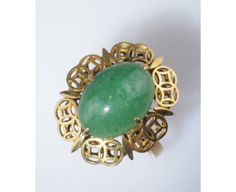 Jade-Ring. Jade-Cabochon in filigraner, stilisierter Münzfassung 14 ct. GG China. 20 Jh.