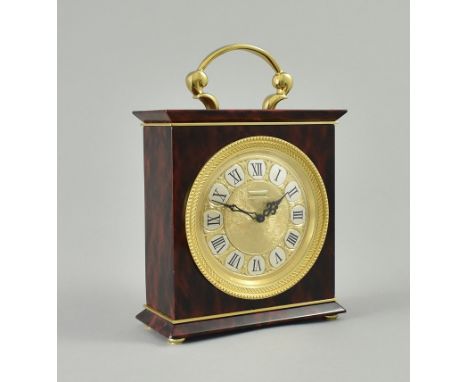 Jaeger-LeCoultre-Tischuhr, Ref. 1230. Kubisches Gehäuse mit Tragebügel, belegt mit marmorierten weinroten Paneelen. Vergoldet