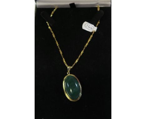A JADE PENDANT, IN A 14K GOLD MOUNT, ON A 22K GOLD CHAIN, GROSS WEIGHT 21G