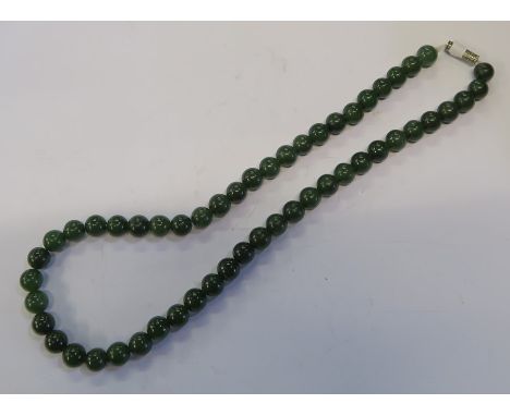 A NECKLACE OF JADE BEADS, WITH A WHITE METAL CLASP, GROSS WEIGHT 42G