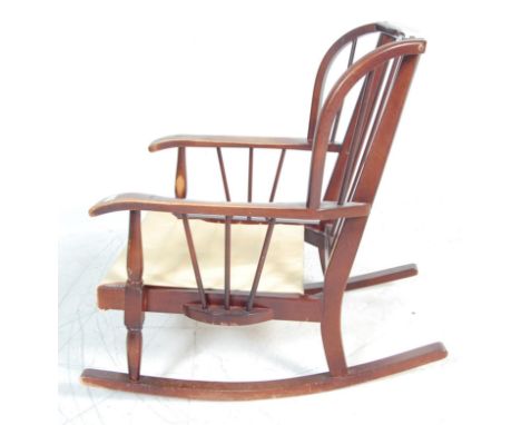 A vintage retro stained beech Ercol style rocking chair having a stick back with shaped arms and raised on sleigh rockers, co