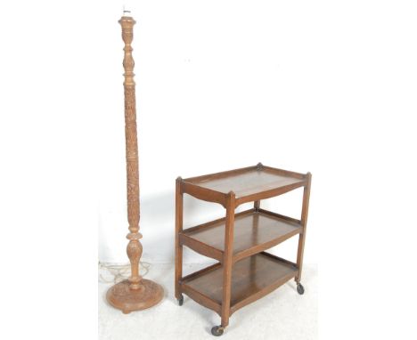 A vintage late 20th century teak standard lamp having a profusely carved column and base together with a 1940s post war oak t