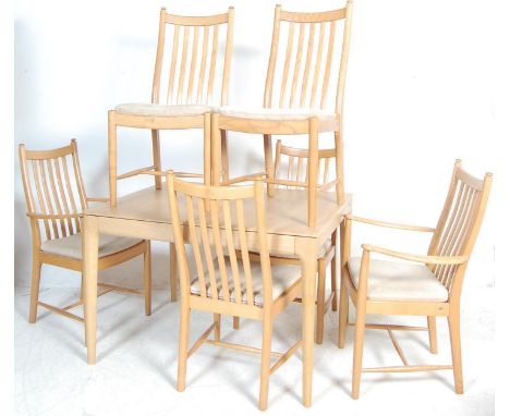 A vintage ercol beech wood extending dining table having a rectangular top raised on turned round legs, together with a set o