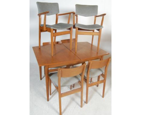 A vintage retro 20th century circa 1960’s teak wood extending dining table and six chairs by Scandart. The table having two p