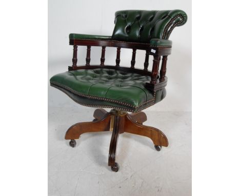 A vintage 20th Century captains office desk swivel chair having a chesterfield style green leather button back seat and backr