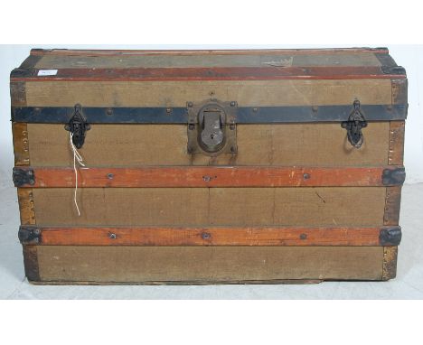 An early 20th century circa 1930’s shipping trunk / storage trunk. The trunk having a dome top canvas covered body with woode