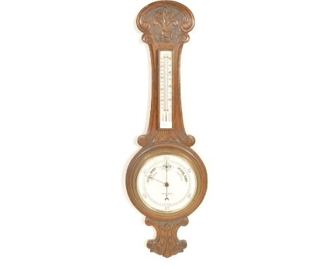A 19th century Victorian carved oak banjo barometer having floral decoration with a thermometer gauge to the top and a circul